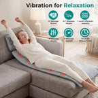 Woman stretching on a sofa while lying on the gray massage mat, with icons for 10 motors, massage modes, intensity, speeds and a 10 to 30 minute timer