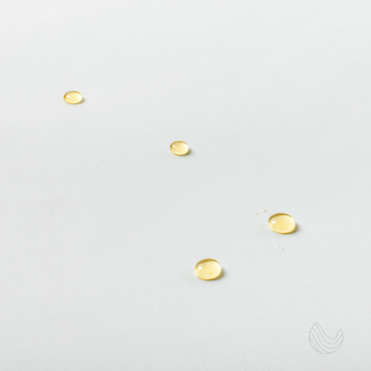 Drops of Innatus Breathe essential oil on a white surface