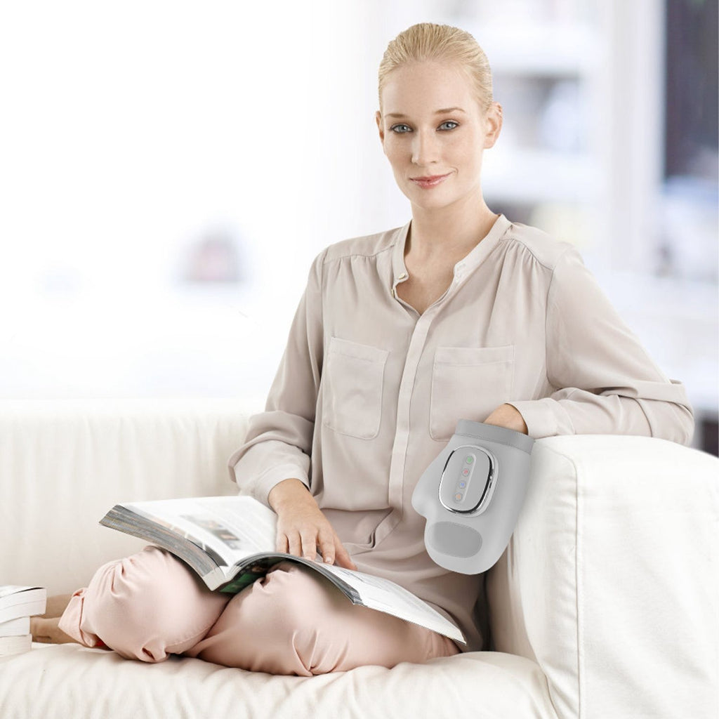 Woman reading on a sofa with her hand in the massager