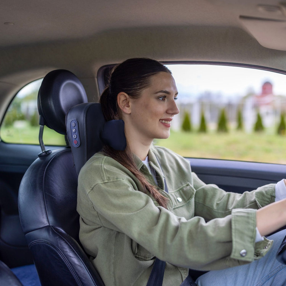 Woman driving with the navy neck massager strapped behind her neck