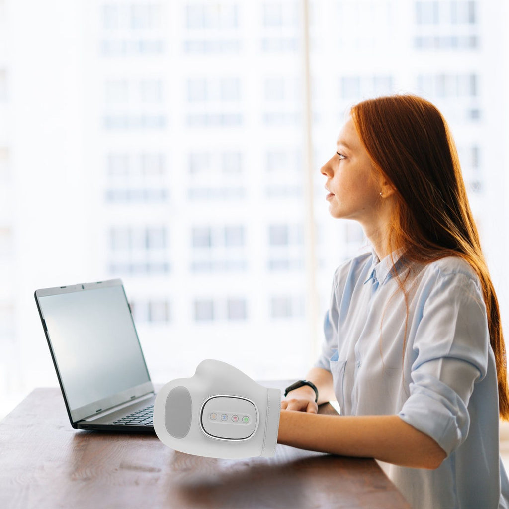 Woman working at a laptop with her hand resting in the massager