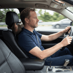 Man driving with the massage pillow behind his neck