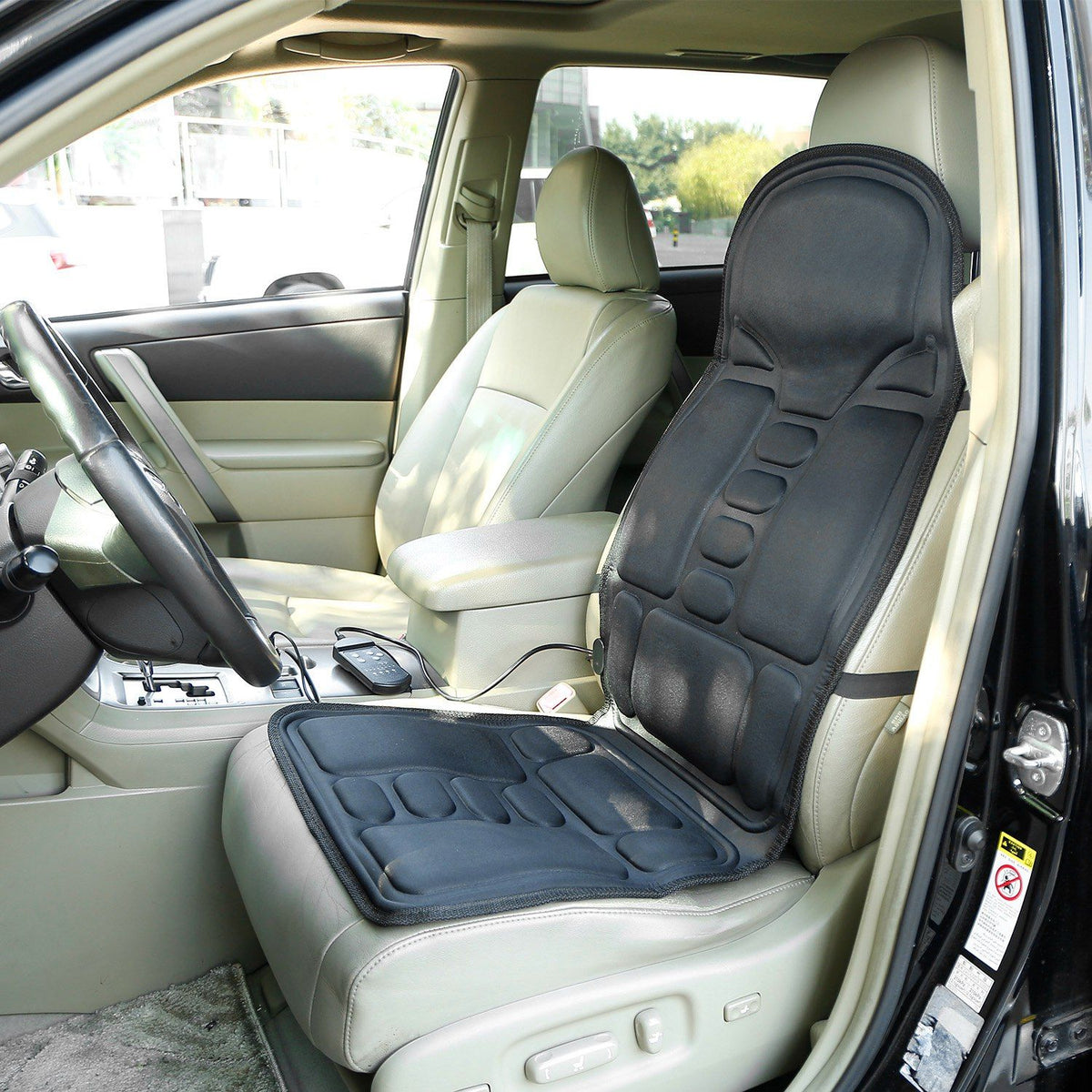 Massage seat cushion strapped to the front seat of a car