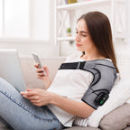 Woman using her phone on a sofa while wearing the shoulder wrap